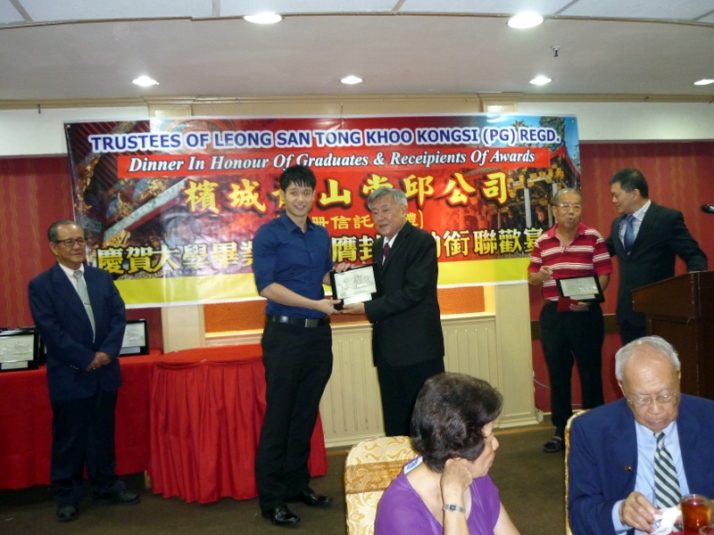Khoo Kay Hock presenting a plaque to a Graduate.